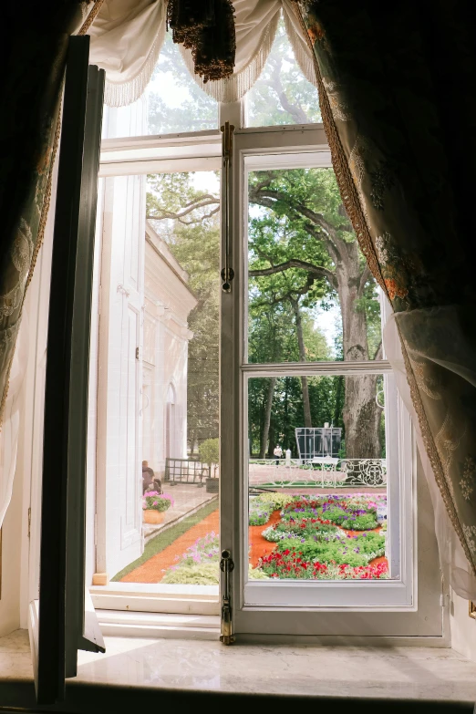 an open window in the middle of a home with flowers