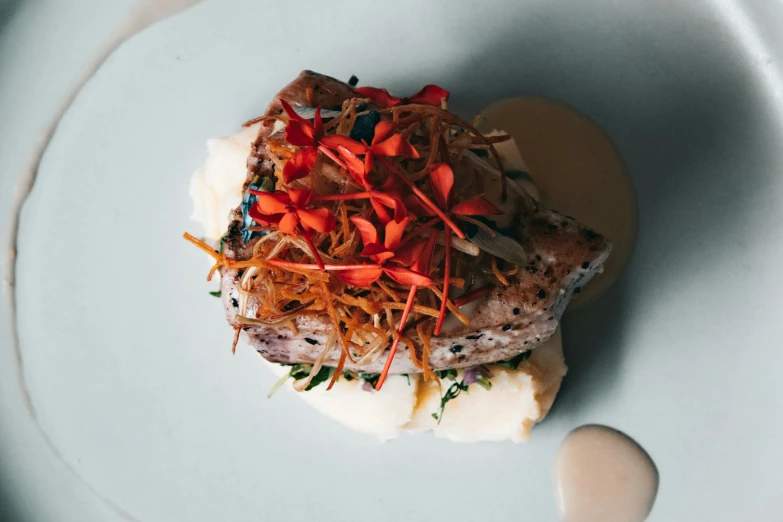 a plate topped with meat, veggies and mashed potatoes