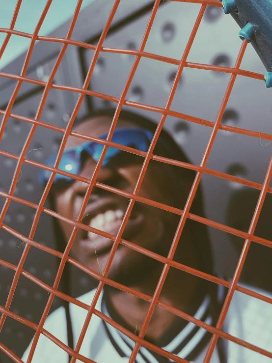 a person inside a red fence with a blue camera