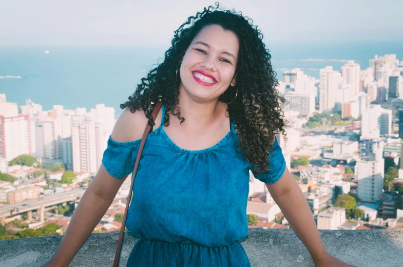 a woman is posing for a po with the city in the background