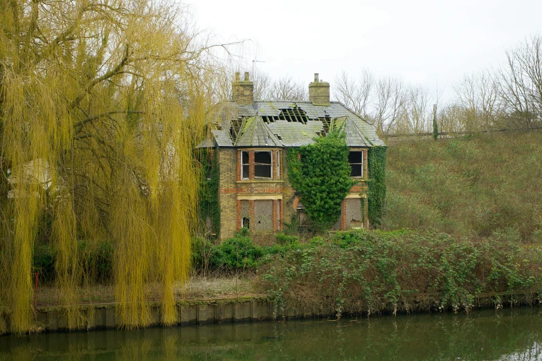 an old abandoned building by the riverbank in autumn