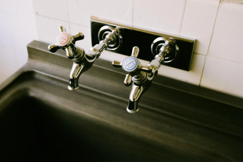 two taps on the bathroom wall are connected to the water in the faucet