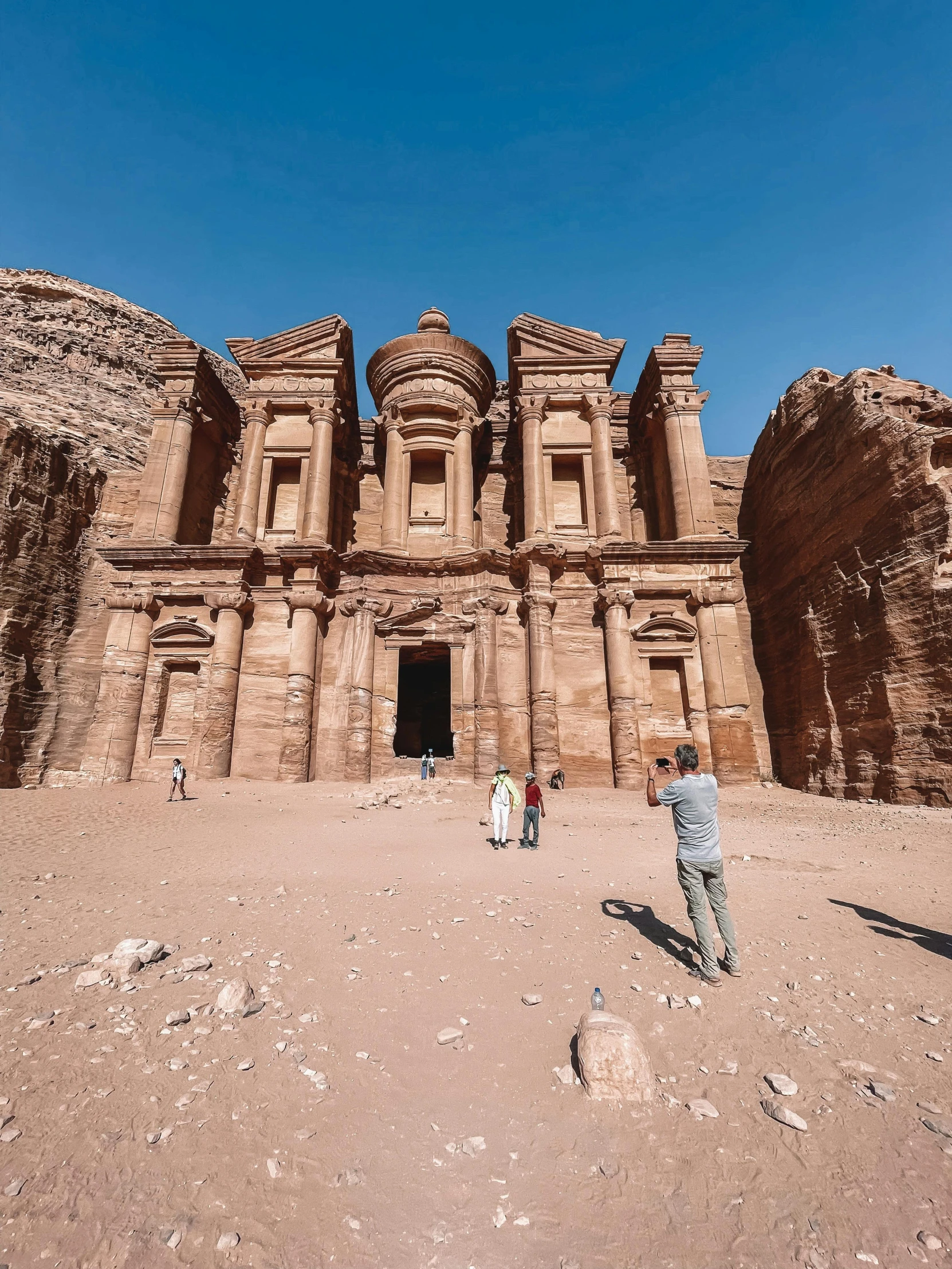 a man taking a pograph in front of a large building