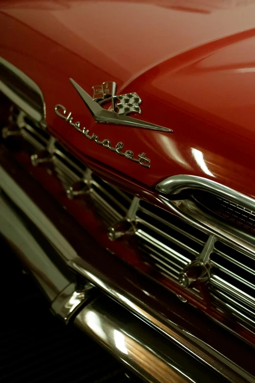 a classic car, red and chrome, with chrome lettering