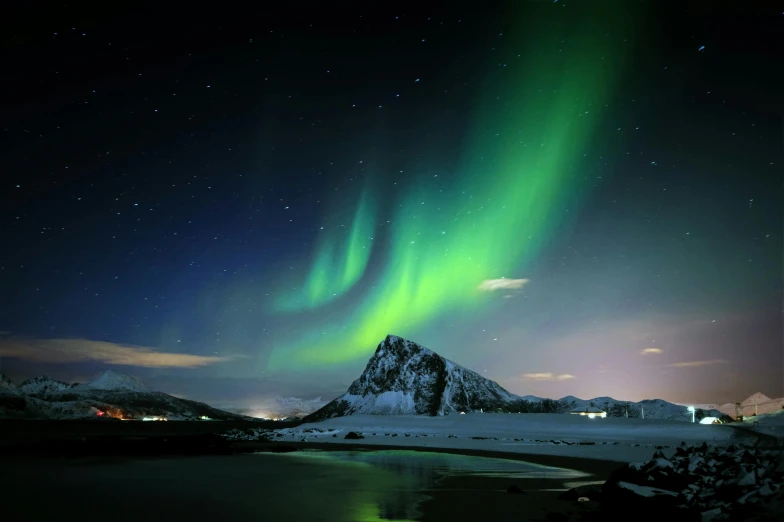 some snow mountains a lake and green and blue aurora lights