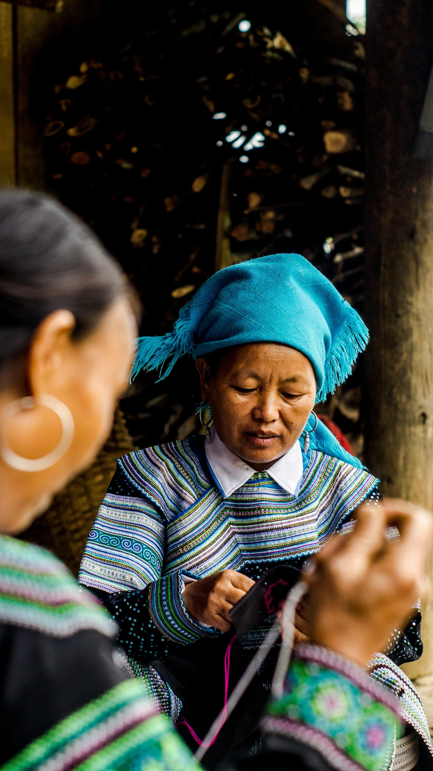 a woman looking down at the string on her needle