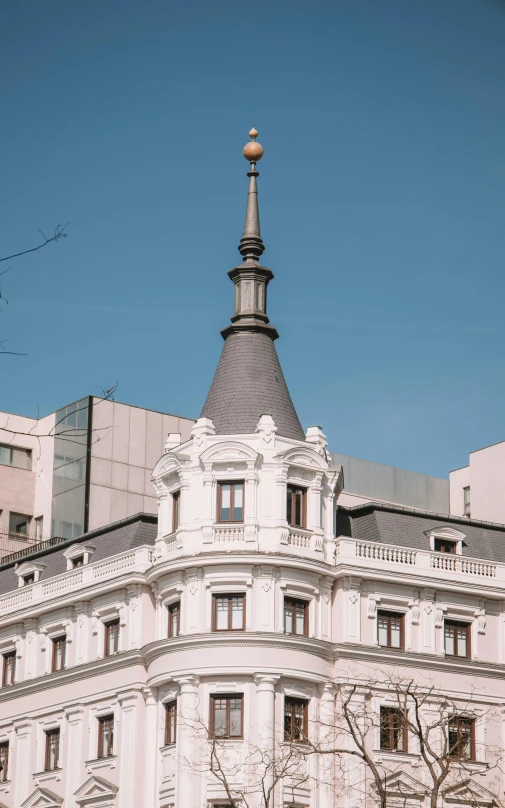 a tall building with a black roof and a clock on the top