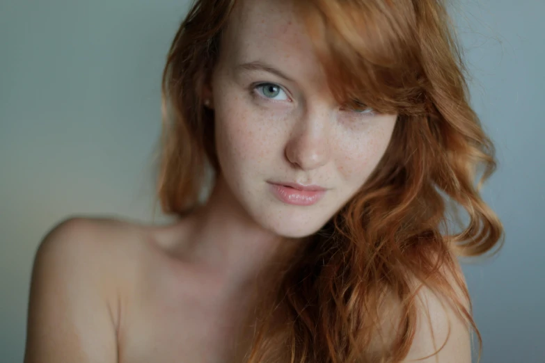 a girl is posing for the camera, red - headed