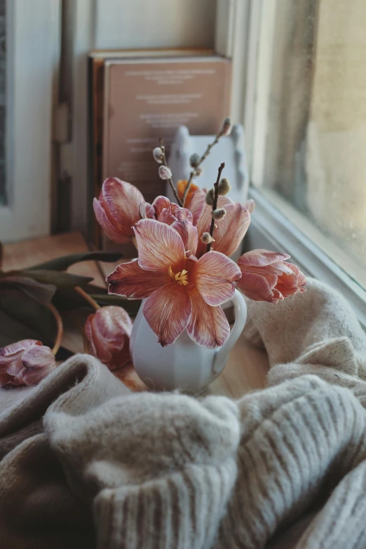 a bouquet of flowers sitting in a gray vase next to a window