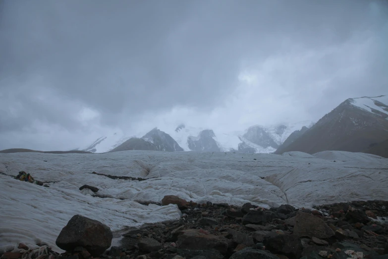 there are snow covered mountains and rocks in the field