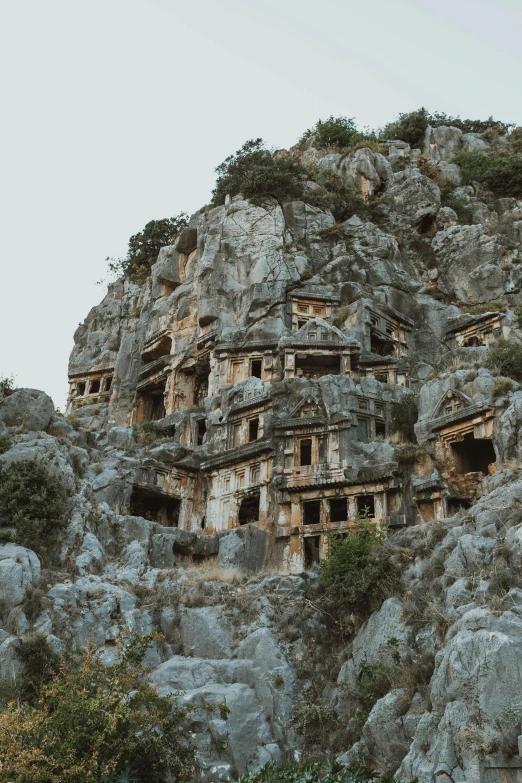 a huge rock formation has small building built into it