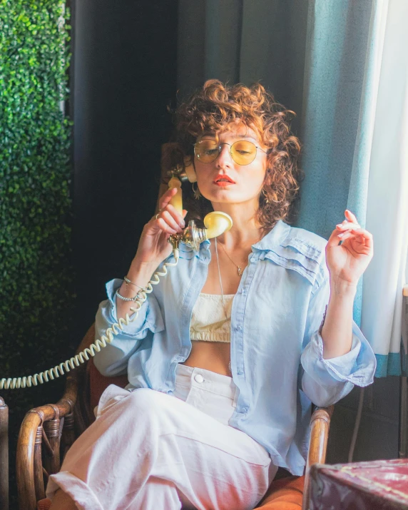 a woman in a blue blouse talking on a phone