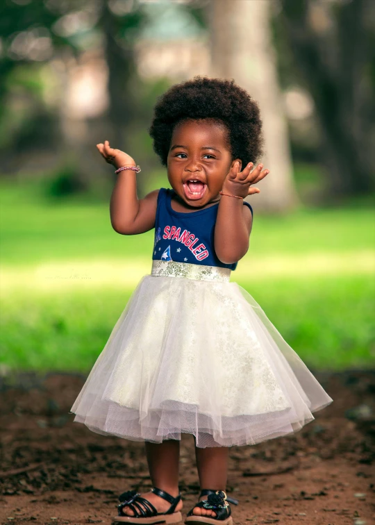 a little girl holding her hands up in the air