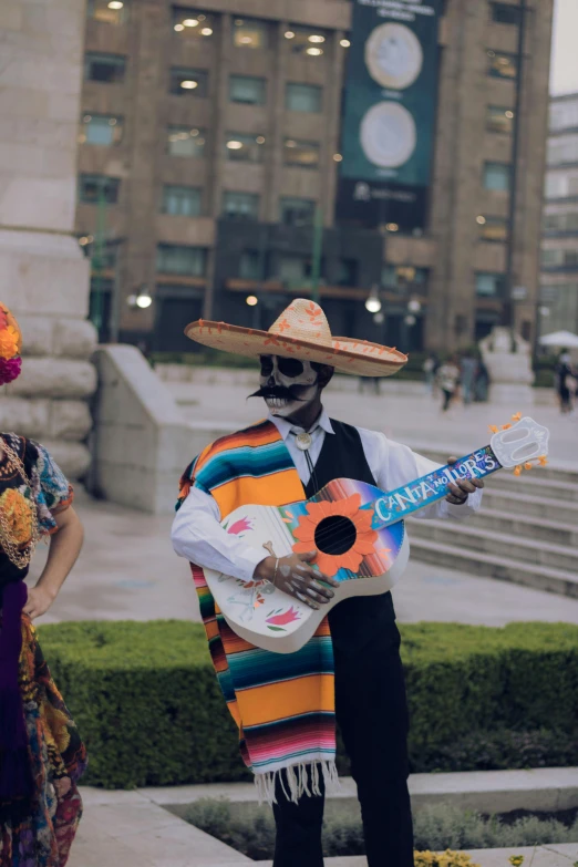 two people in costumes play guitar and smile