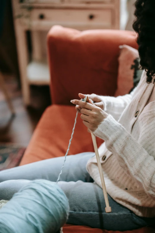 a woman in white shirt sitting on chair holding a yarn