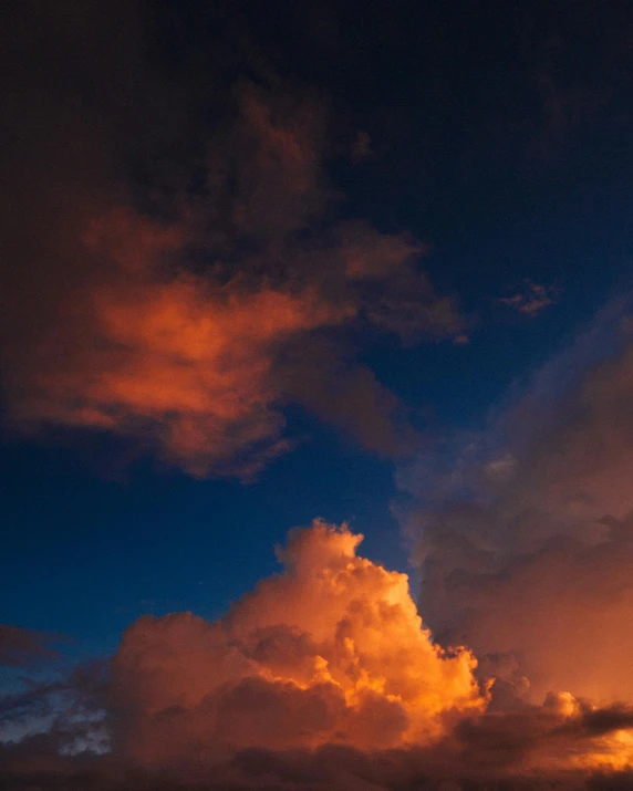 the clouds are starting to appear orange, while the sun is in blue