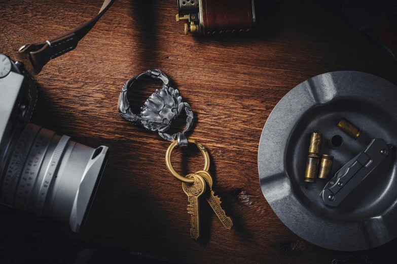 two metal bottle openers next to a camera and two smaller bottles