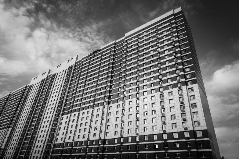 the tall building is made of windows and has no trim around its edges