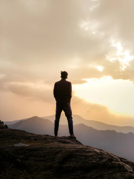 a man in the distance standing on top of a mountain