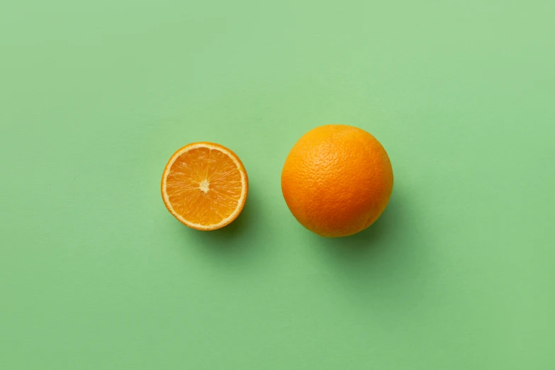 an orange on the green background with half peeled