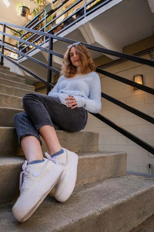 the woman is sitting down on stairs by herself