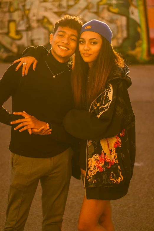 a man and a woman smile for the camera, wearing matching clothes