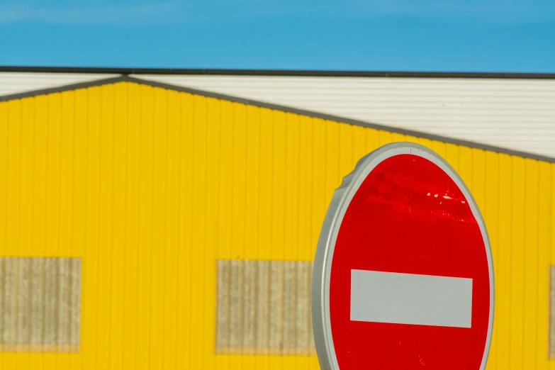 a large yellow building with two white and red surfboards