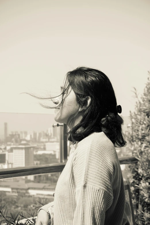 a woman in a sweater looks over a ledge