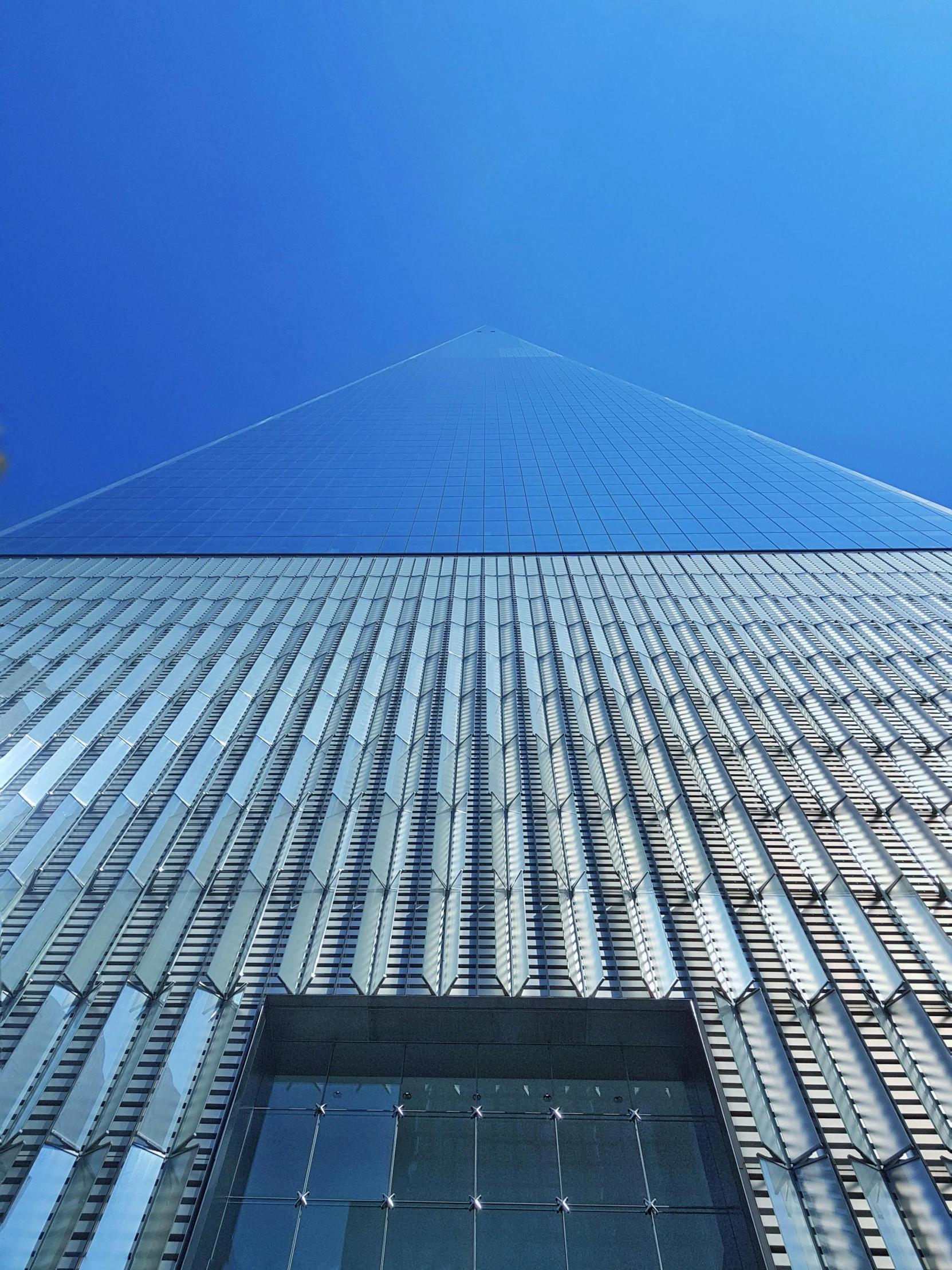 a tall building stands high against a blue sky