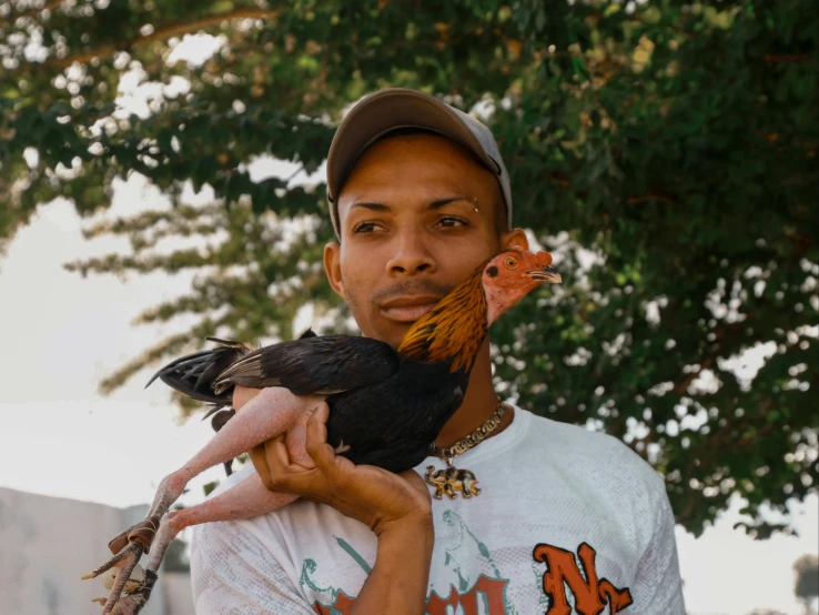a man holding two large chickens in his hands