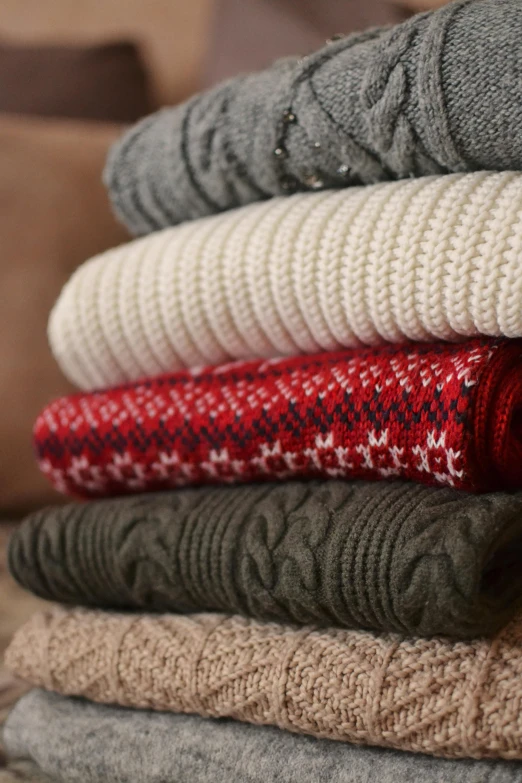 knitted scarves are stacked in a pile