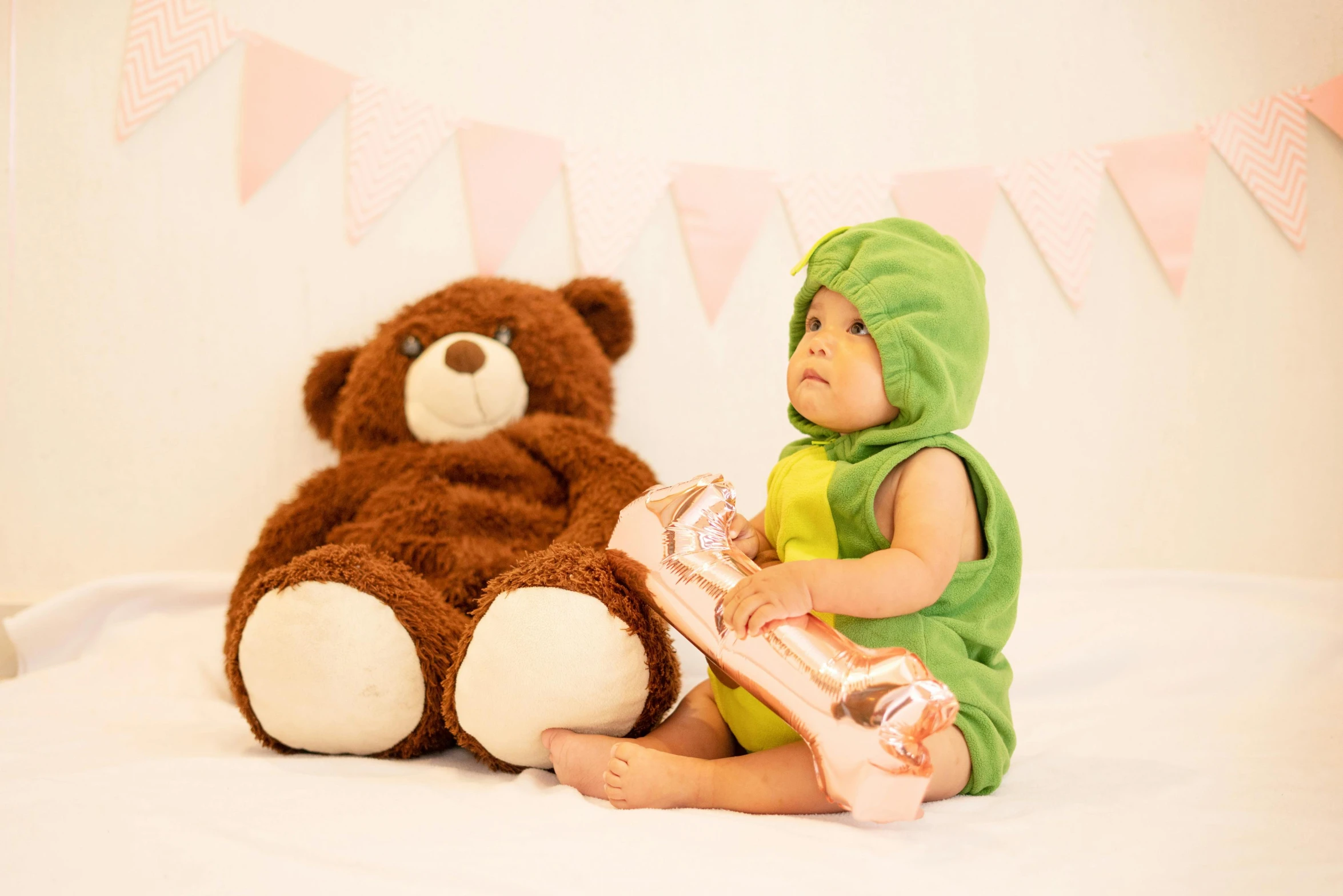 a baby sitting next to two stuffed animals