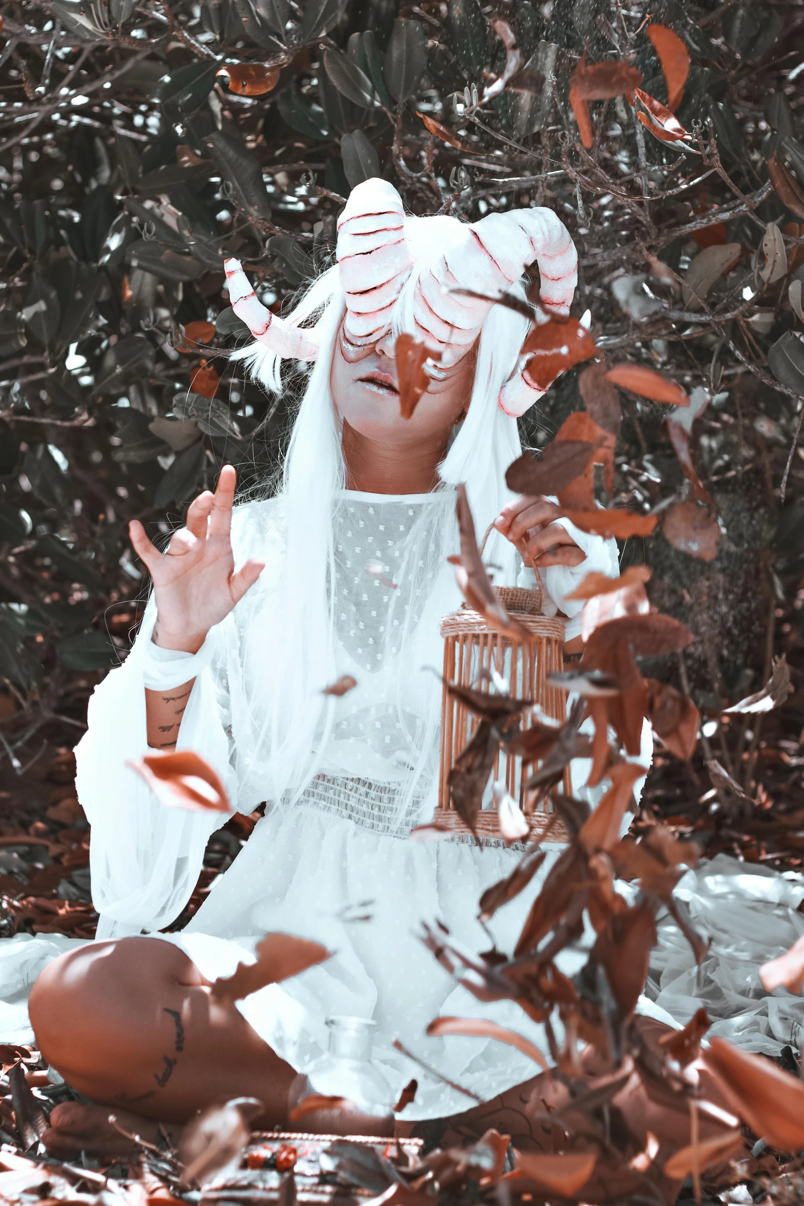 woman in white dress with hand to head near tree