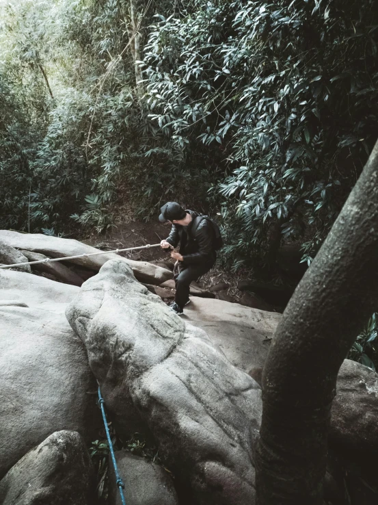 a man climbing up the side of a large rock