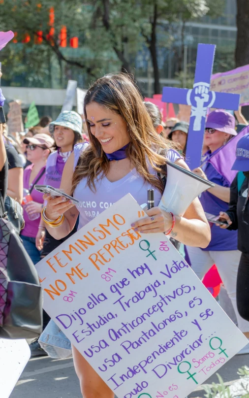 a woman with signs in her hand, with others holding a sword