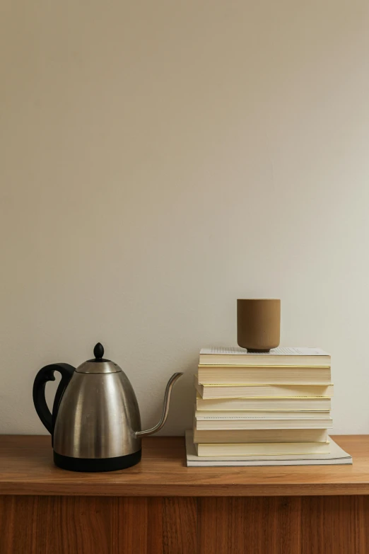 a table with a kettle, books and a lamp