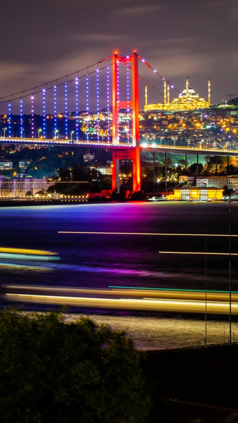 lights from cars streak across a body of water