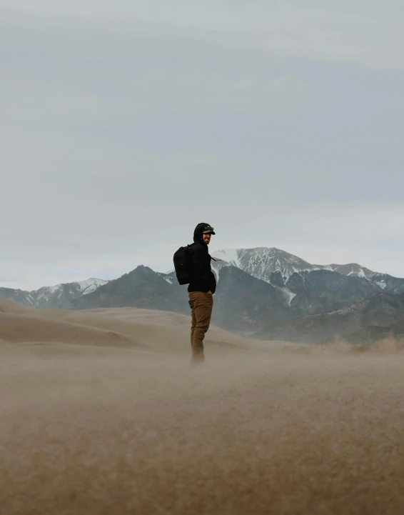 a person standing in the middle of a field of sand