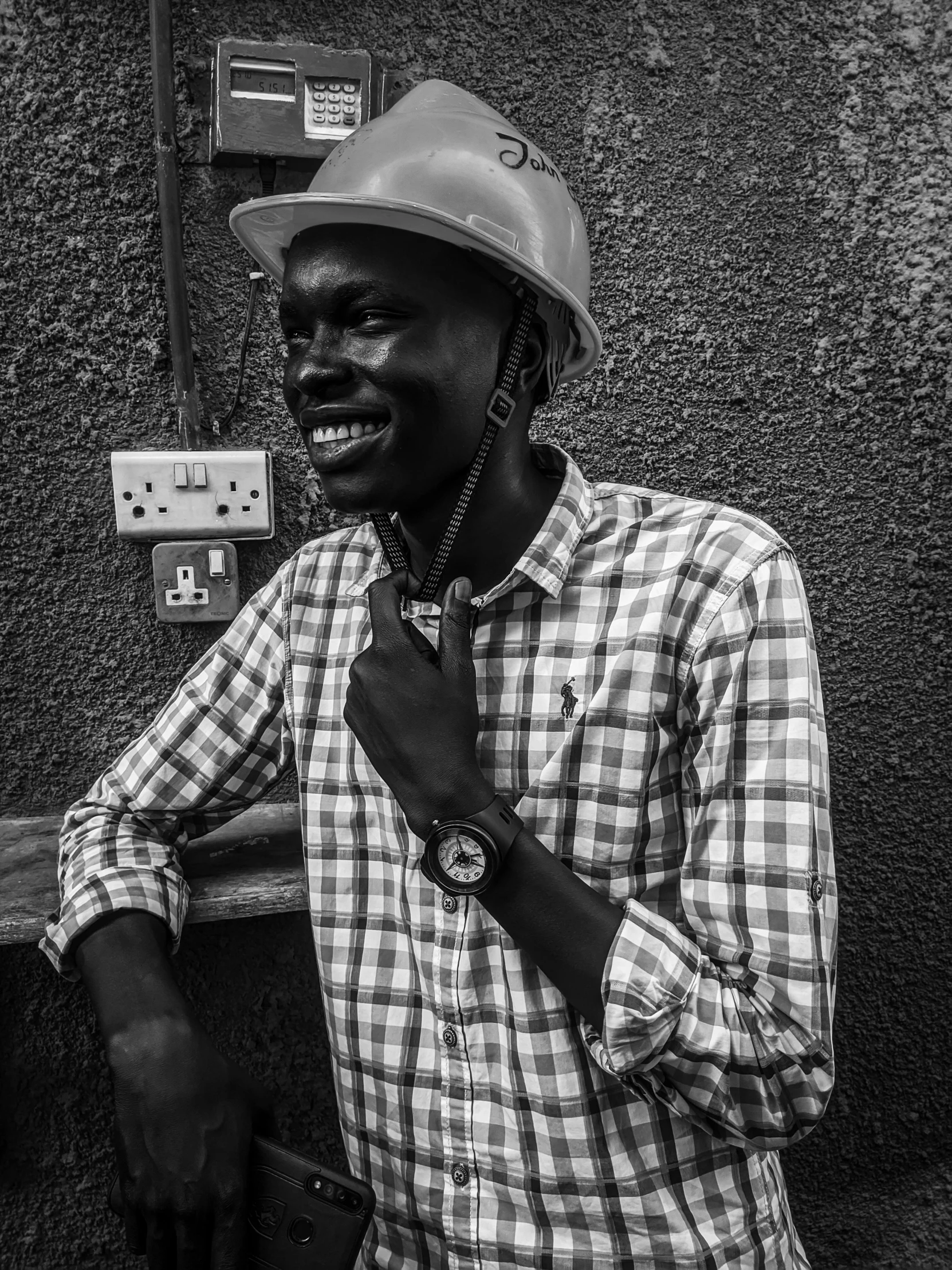 man with a hardhat stands next to an electrical meter