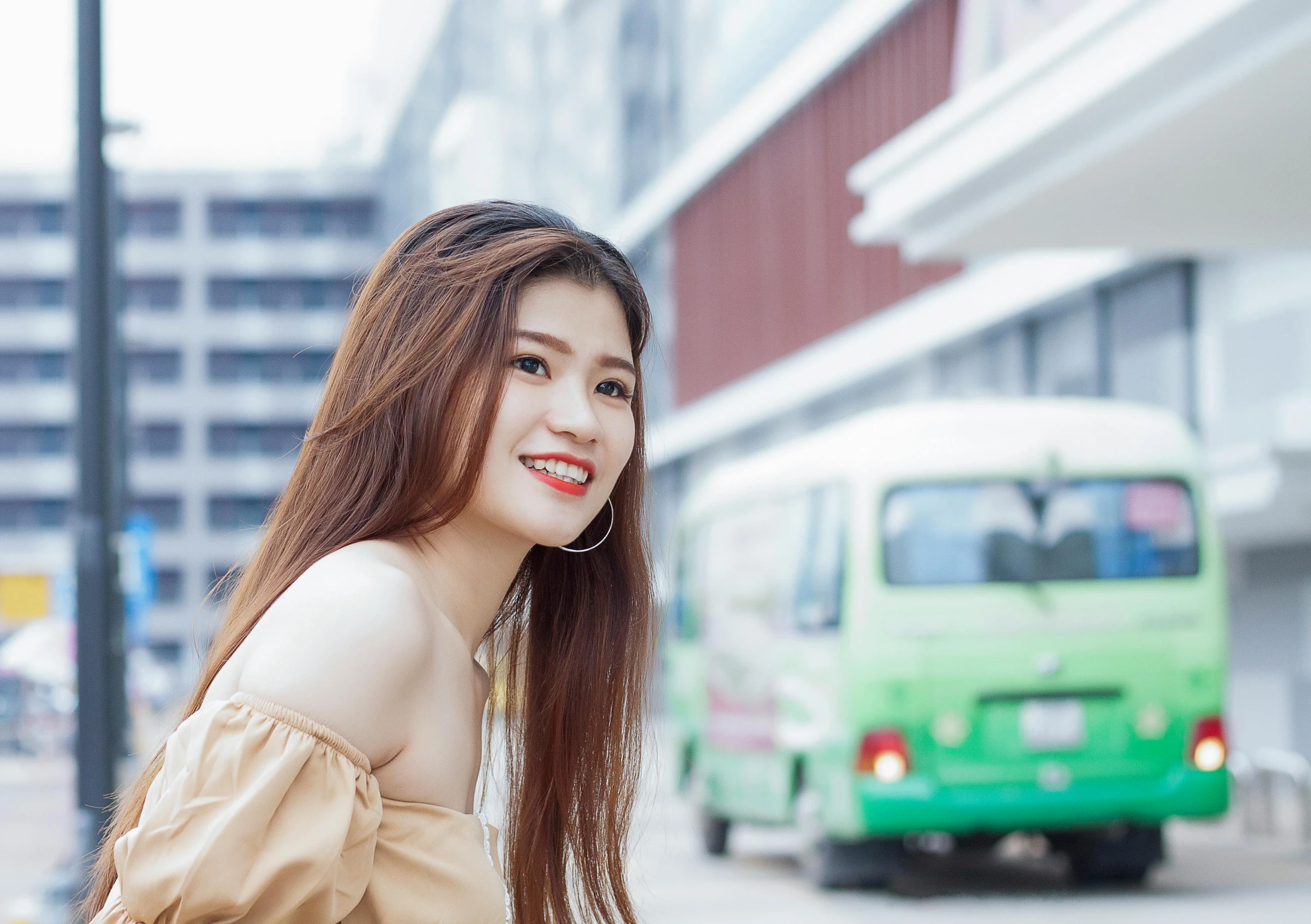 a pretty young lady with long hair standing next to a street