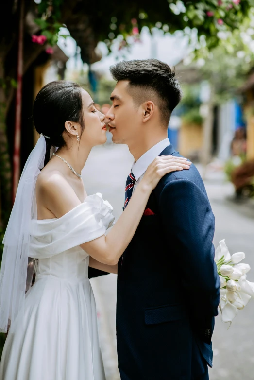 a young bride kissing her groom on the forehead