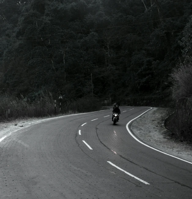 a motorcycle with a rider driving along the road