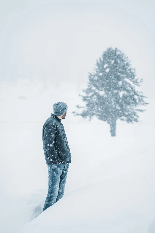 a man standing in the snow with his back turned