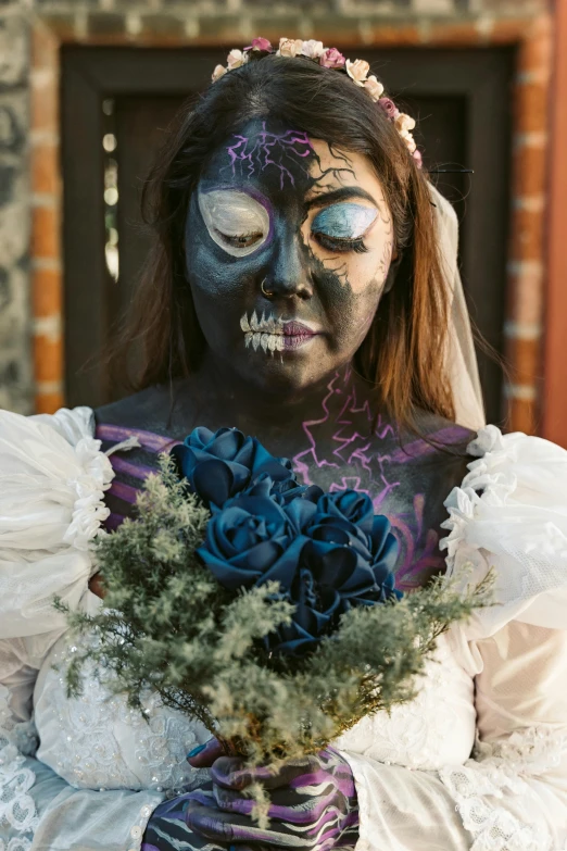 woman with makeup and skeleton face paint holding a flower bouquet