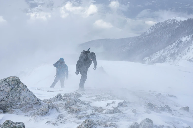 three men walking on a snowy mountain side