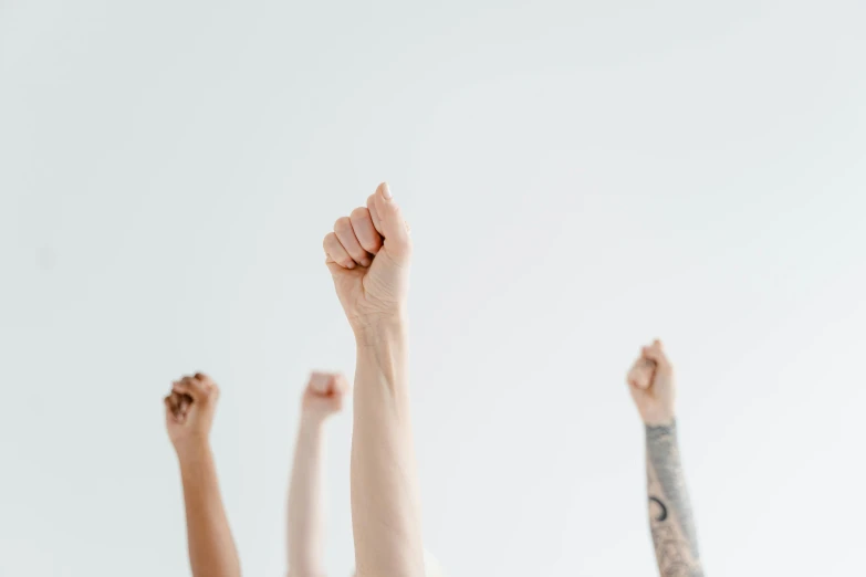 a group of women raising their arms to the sky