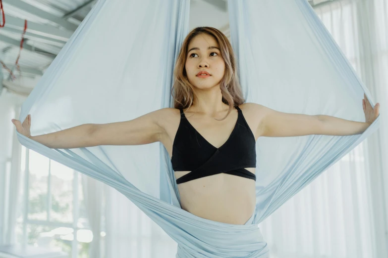 a young woman posing for a po in a black bikini top with a light blue canopy