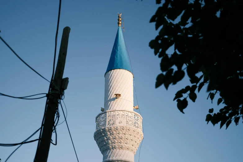 a large tower with a blue top is under the trees