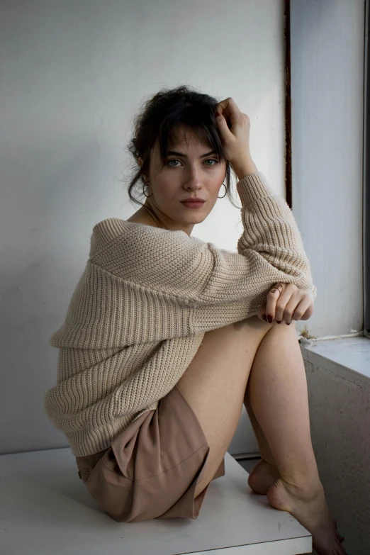 a young woman sitting on the floor with her hand under her head