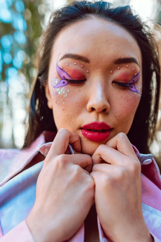 a woman with pink makeup and artistic make up